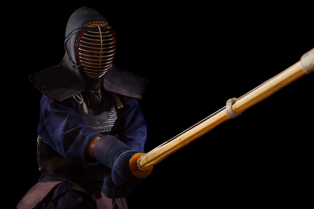 Kendo practitioner in the fighting stance called Kamae and holding the bamboo sword(Shinai) in front with both hands